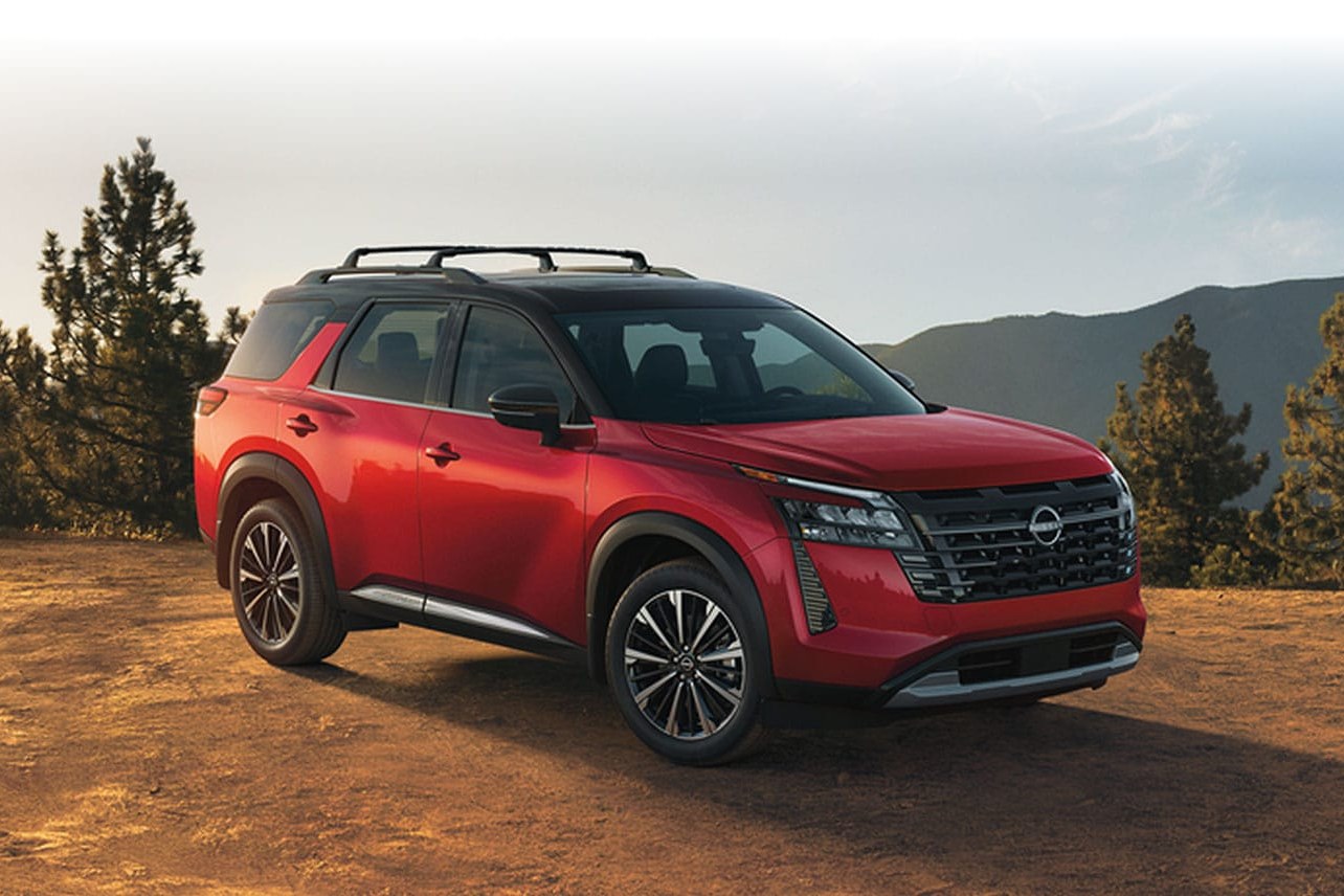2026 Nissan Pathfinder front three-quarter view parked on a dirt hill with pine trees