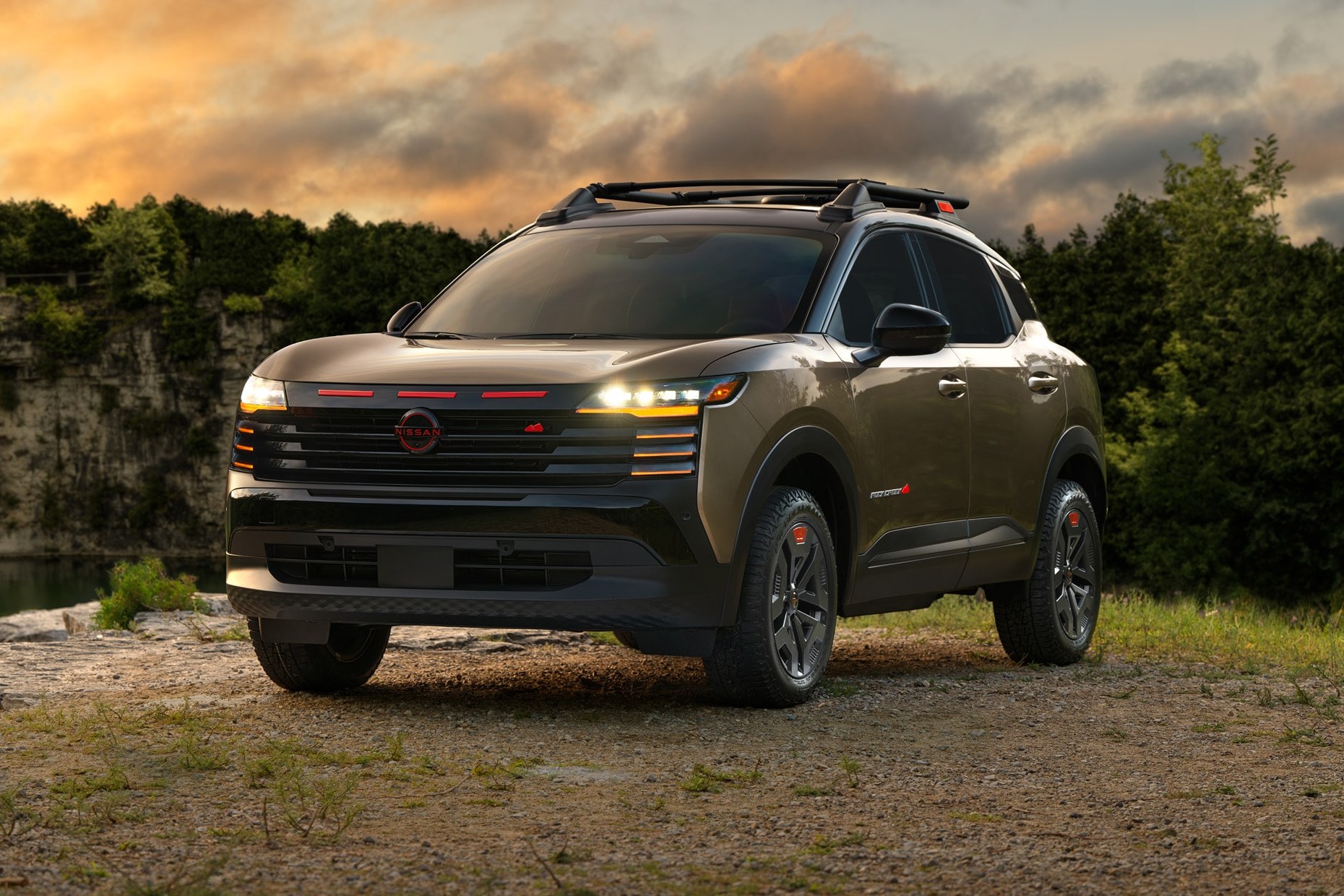 2027 Nissan Kicks Rock Creek parked on a gravel clearing at sunset front three-quarter view parked